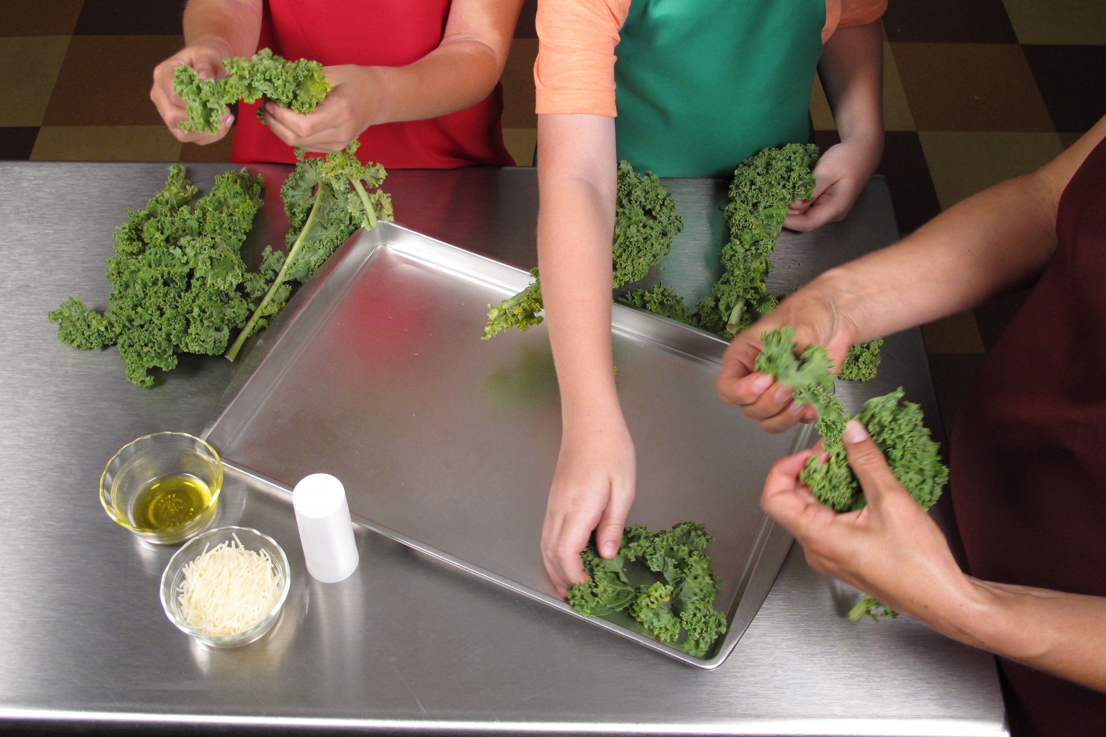 Carefully tear kale leaves from the thick stem. Tear into bite-sized pieces and place on baking sheet.