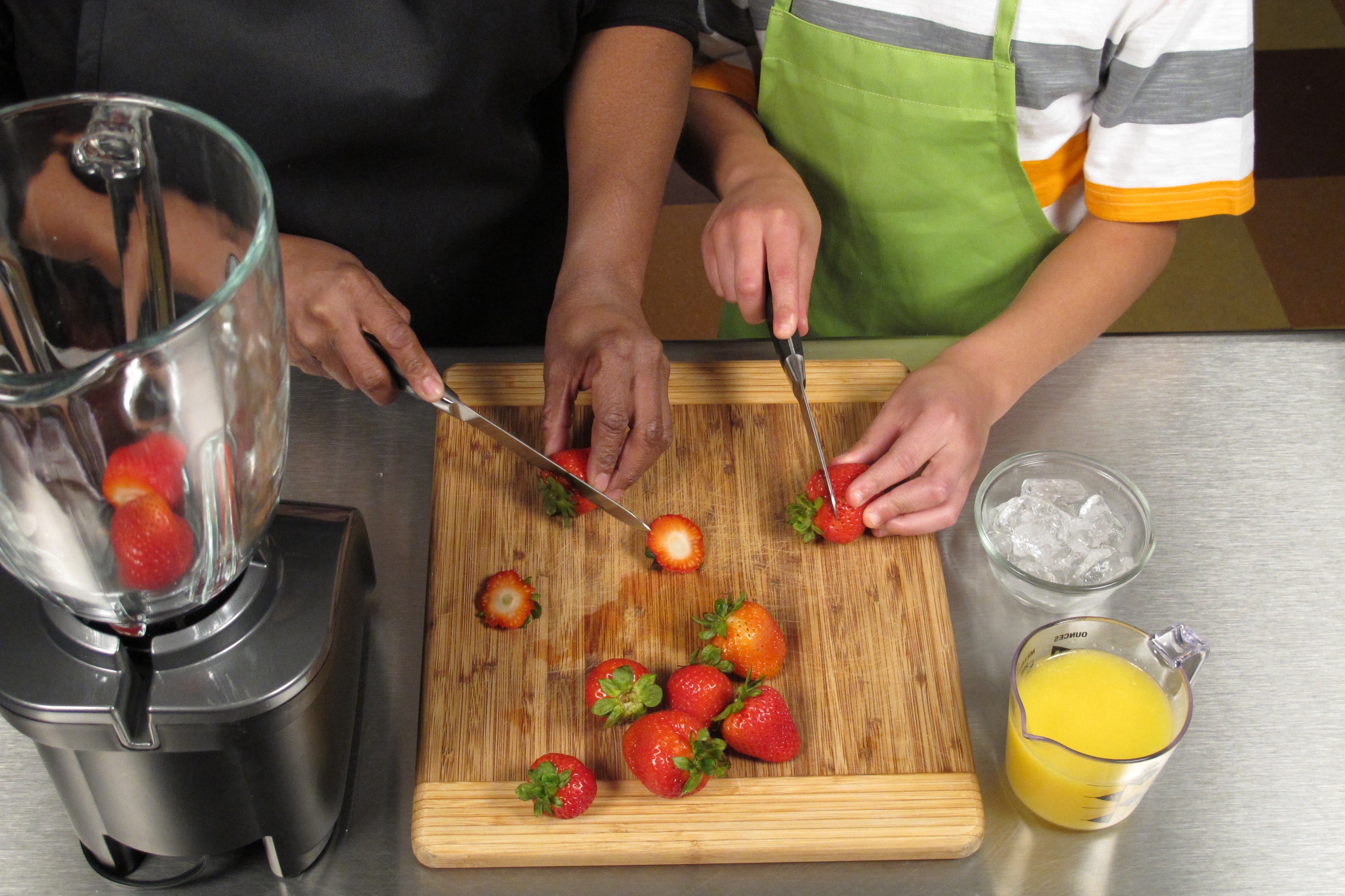 Remove stem and leaves and cut strawberries in half. Younger children can use a plastic knife for this step if desired.