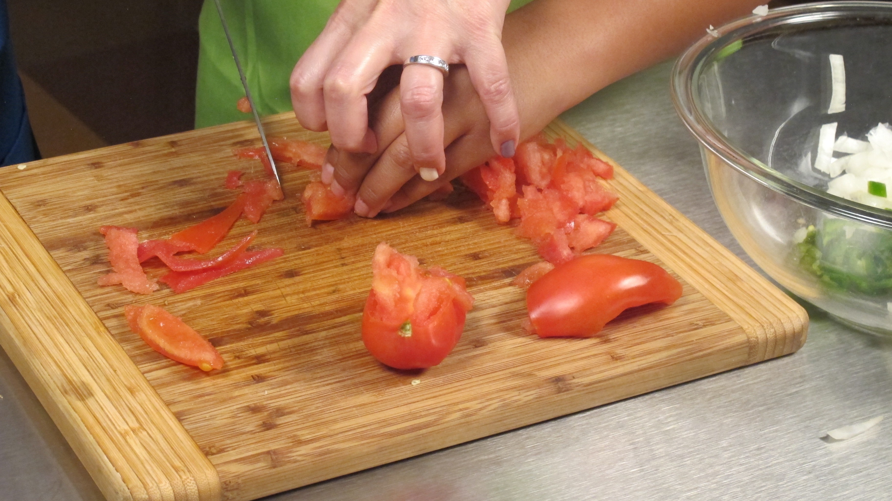 Cut tomatoes in half. Scoop or squeeze out seeds and throw away. Chop tomatoes and place in bowl.